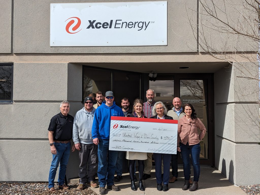 A group of Xcel employees and United Way board members stand in front of Xcel Energy's Menomonie Office with a huge check made out to United Way of Dunn Co. 