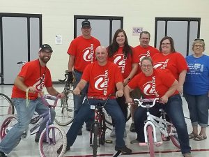 Volunteers posing with bikes to donate